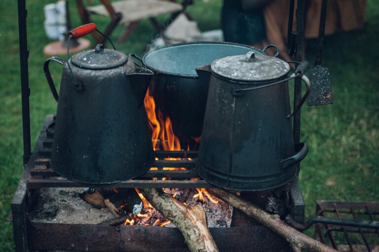 Exploring the Different Types of Outdoor Camping Stoves: Advantages and Disadvantages 2 two kettles and one pot on top of fire